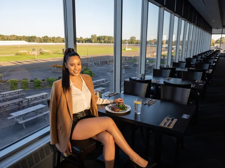 Woman at a window table above the racetrack